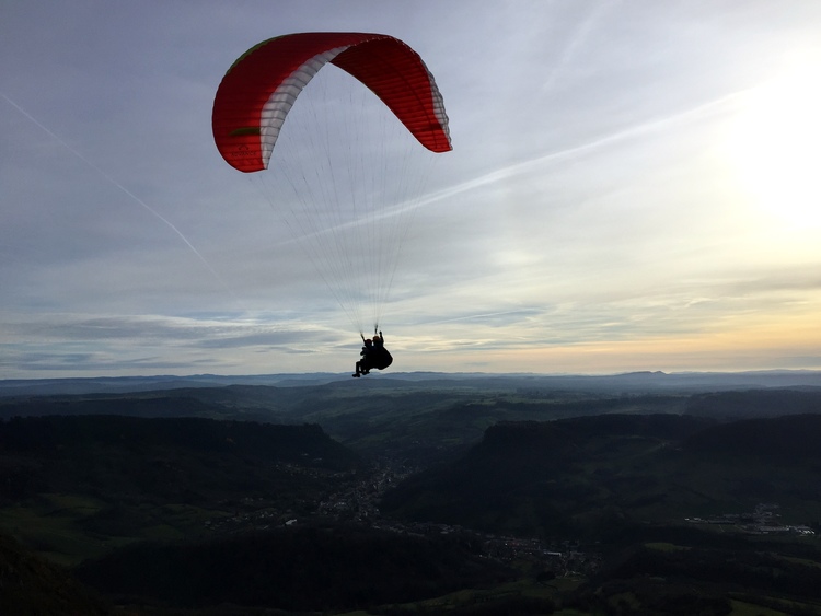 biplace beta 6 rouge au dessus de la ville de Salins les bains mout poupet parapente